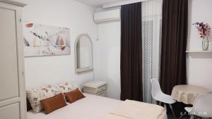 a small bedroom with a bed and a table at Pejovic Guest House in Sutomore