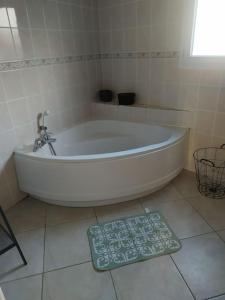 La salle de bains est pourvue d'une baignoire blanche et d'une balance. dans l'établissement Schumann Jardin Vannes, à Vannes
