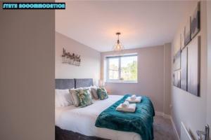 1 dormitorio con 1 cama con 2 toallas en Free Private Parking Modern 2 Bed Apartment Vine Ct 5 en Dorking