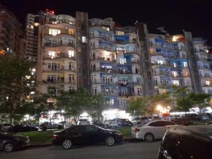 a large building with cars parked in a parking lot at Apartment near the sea in Batumi