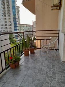 a balcony with a chair and potted plants on it at Apartment near the sea in Batumi