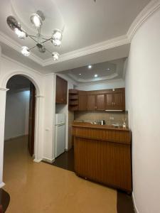 a kitchen with wooden cabinets and a ceiling at Apartment near the sea in Batumi