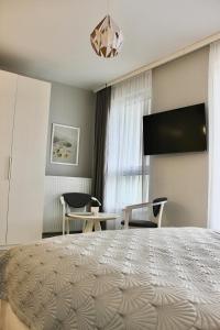 a bedroom with a large bed with a flat screen tv at LuxApartmentWarszawa z bezpłatnym podziemnym parkingem in Warsaw