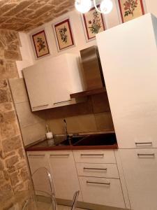 a small kitchen with white cabinets and a sink at Suite Duomo Trani 6 in Trani