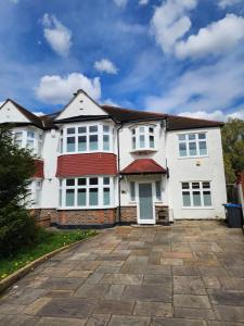 a white house with white windows and a driveway at Countryside Home in London in Shirley