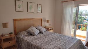 ein Schlafzimmer mit einem Bett und einem großen Fenster in der Unterkunft Una casa con vistas in Faro de Cullera