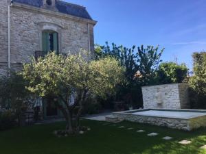 a stone house with a tree in the yard at Chambre Foret du Mas des Fontaines in Montagnac +29 photos