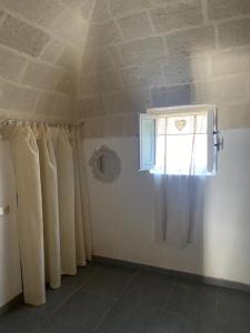 Zimmer mit einem Vorhang, einem Fenster und einer Decke in der Unterkunft Salenti..amo in Pulsano