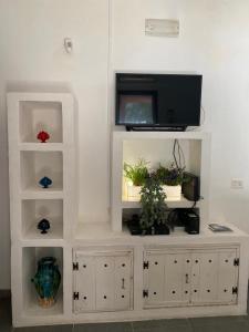 un centro di intrattenimento bianco con una tv su un muro di Salenti..amo a Pulsano