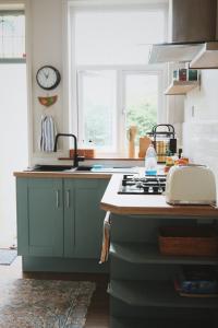 una cocina con fregadero y estufa horno superior en A cosy garden flat in a quiet area close to the city centre, en Bristol