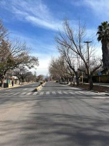 una calle vacía con árboles a ambos lados de la carretera en Departamento en Vistalba, Lujan con vista a la Montaña en Luján de Cuyo