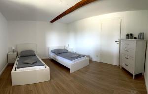 a bedroom with two beds and a dresser at Moderne Ferienwohnung mit Terrasse in Guxhagen