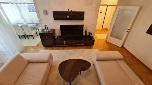 ein Wohnzimmer mit einem Sofa und einem Tisch in der Unterkunft Sarajevo City Deluxe Apartment in Sarajevo