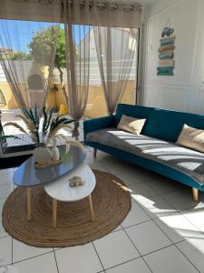 salon z niebieską kanapą i stołem w obiekcie Maison Résidence Golf Club Cap Agde w Cap d'Agde