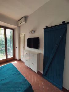 Schlafzimmer mit einer blauen Schiebetür mit einem TV in der Unterkunft Border House in Fiesole