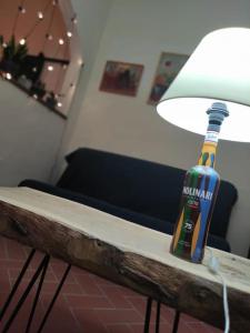 eine Flasche Bier auf einem Tisch mit einer Lampe in der Unterkunft Border House in Fiesole