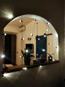 einem Spiegel mit Licht und Topfpflanzen auf einem Regal in der Unterkunft Border House in Fiesole