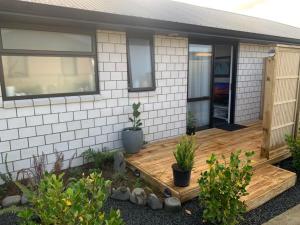 a porch of a house with a wooden deck at Hall Street Haven in Te Awamutu