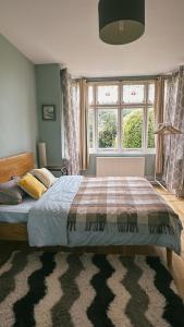 1 dormitorio con cama y ventana grande en A cosy garden flat in a quiet area close to the city centre en Bristol