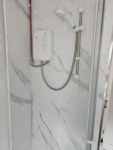 a shower in a bathroom with a marble wall at Skyline king Studio room 201 in Swansea