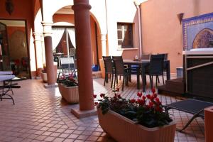 a patio with a table and chairs and flowers at Naturisme Riads Resort 1 Chambre Sidi village naturiste couple only in Cap d'Agde +2 photos