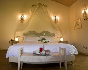 a bedroom with a large white bed with a table at Locanda Del Re Guerriero in San Pietro In Cerro