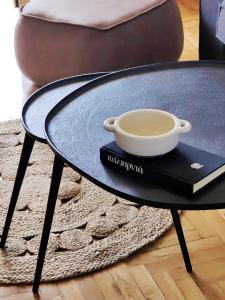 a coffee table with a cup of coffee on a book at Funky Boho Kallithea Loft in Athens