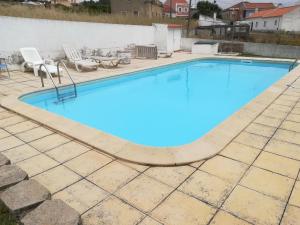 een zwembad met blauw water in het midden bij Camarção Violante in Foz do Arelho