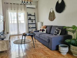 a living room with a blue couch and a table at Funky Boho Kallithea Loft in Athens