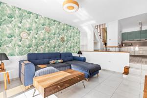 un soggiorno con divano blu e una cucina di AleSol Tenerife a Playa Fañabe
