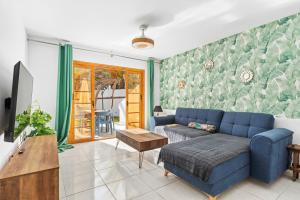 un soggiorno con divano blu e TV di AleSol Tenerife a Playa Fañabe