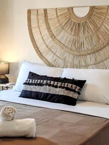 a bedroom with a large bed with a rattan headboard at Funky Boho Kallithea Loft in Athens