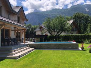 een achtertuin met een zwembad en een huis bij Chalet Barbara with swimming pool in the heart of Oisans in Le Bourg-dʼOisans