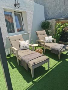 two chairs and two beds on a patio with grass at *Enjoy* in Šibenik