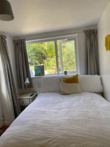 a bedroom with a large bed with a window at Light airy comfy small double room with en-suite in Falmouth +10 photos