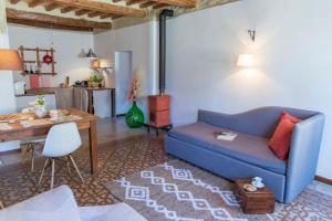 - un salon avec un canapé bleu et une table dans l'établissement Leontine Home in Mondaino by Yohome, à Mondaino