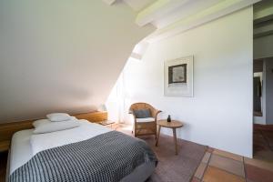 a bedroom with a bed and a chair and a table at Quartier Carpe Diem in Prerow