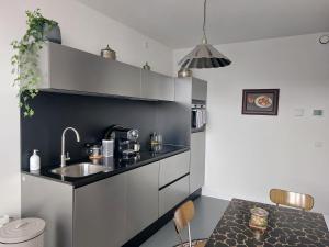 a small kitchen with a sink and a table at Medina B&B hartje Arnhem in Arnhem