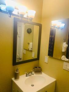 ein Bad mit einem Waschbecken und einem Spiegel in der Unterkunft Luxury 2 bedroom rental place with a fireplace in Colorado Springs