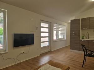a living room with a flat screen tv on a wall at Apartman Anka in Komin