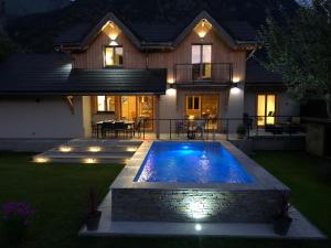een huis met een zwembad in de tuin bij Chalet Barbara with swimming pool in the heart of Oisans in Le Bourg-dʼOisans