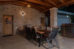 a patio with a table and chairs and a stone wall at Villa Americana 