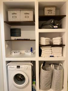 a laundry room with a washing machine and towels at Delta Apartment in Chrissi Akti