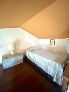 a small bedroom with a bed and a lamp at Amazing house 10 min by car from the beach in Olbia