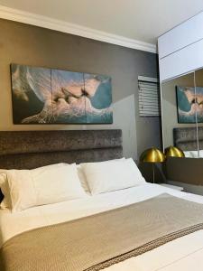 1 dormitorio con 1 cama con 2 cuadros en la pared en Luxuries Penthouse, en Nelspruit