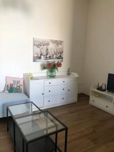 a living room with a table and a white dresser at Le maioliche allo Stagnone kite in Marsala