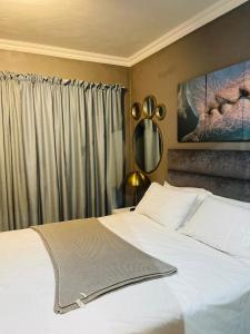 a bedroom with a large white bed and a window at Luxuries Penthouse in Nelspruit