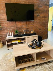 a living room with a tv on a brick wall at Luxuries Penthouse in Nelspruit