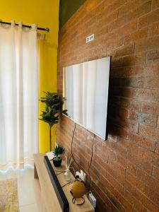 a brick wall with a television on a wall at Luxuries Penthouse in Nelspruit +40 photos