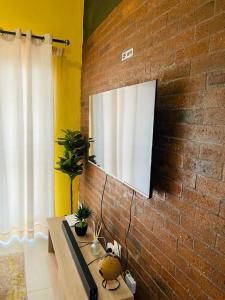 a brick wall with a television on a wall at Luxuries Penthouse in Nelspruit